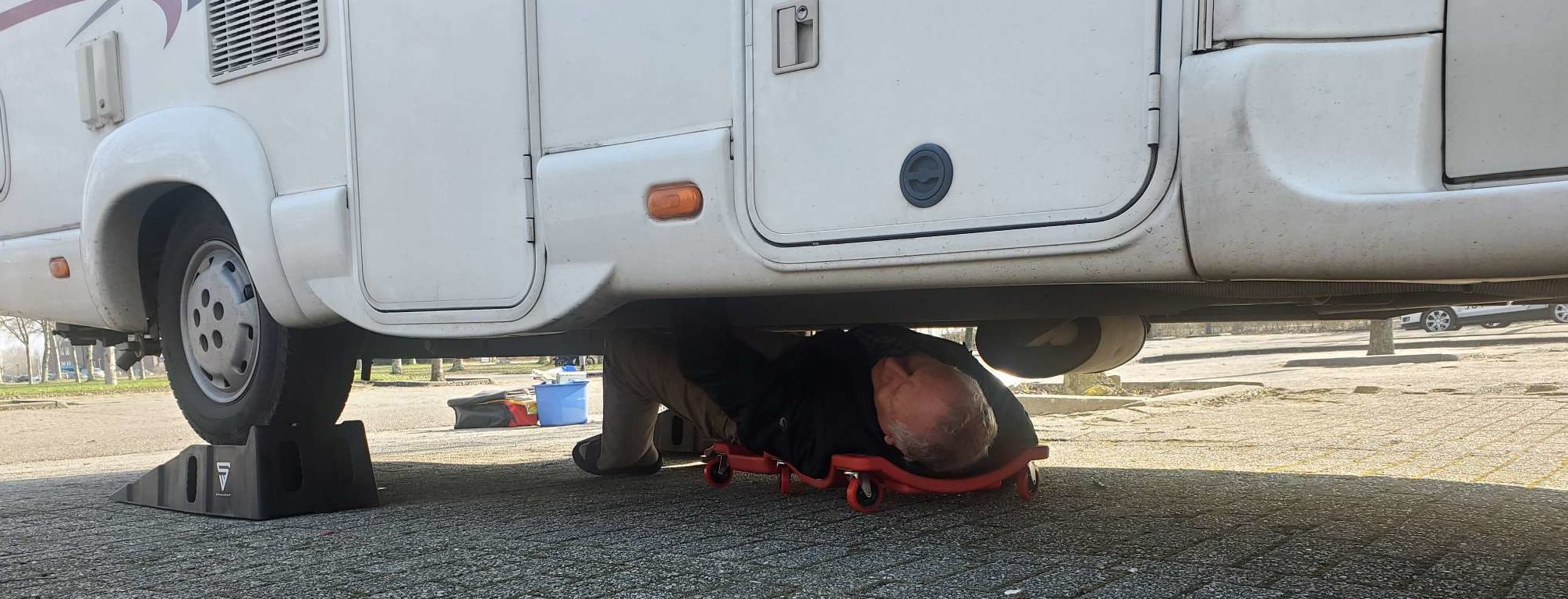 Keurmeester inspecteert de onderkant van een camper